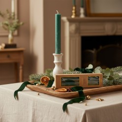 Candela a stelo Verde Bosco EDG su candeliere d'ottone, un dettaglio di lusso su vassoio in legno.